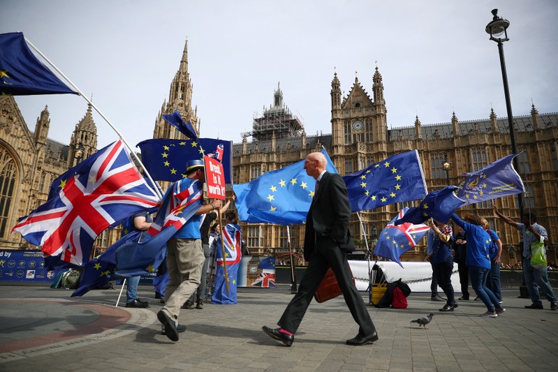 FILE PHOTO: Anti-Brexit demonstrators wave flags outside the Houses of Parliament, in London