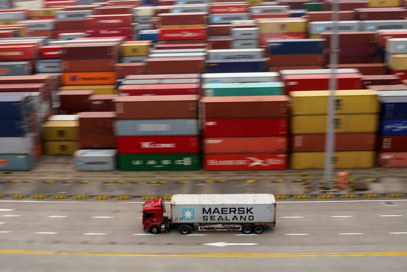 FILE PHOTO: A container truck moves past containers at the Yangshan Deep Water Port in Shanghai