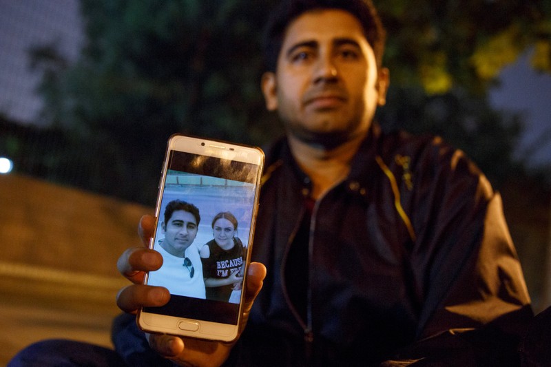 Pakistani businessman Mirza Imran Baig shows a picture of him and his wife Mailikemu Maimati as he sits outside the Pakistani embassy in Beijing