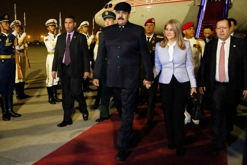 Venezuela's President Nicolas Maduro walks with his wife Cilia Flores upon their arrival at the airport in Beijing