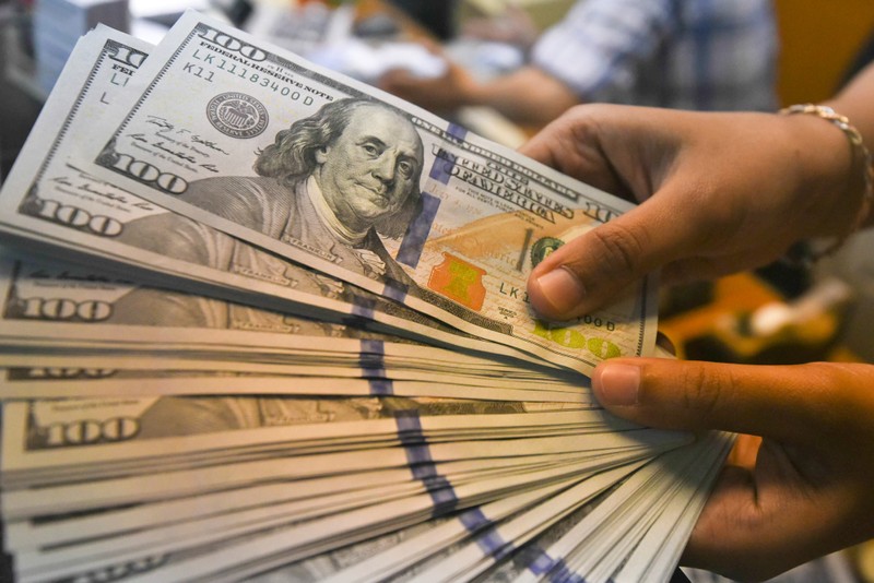 An employee shows U.S. dollars banknotes at a money changer in Jakarta