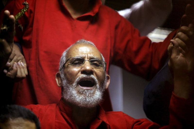 FILE PHOTO: Muslim Brotherhood's Supreme Guide Mohamed Badie reacts with other brotherhood members at a court in the outskirts of Cairo