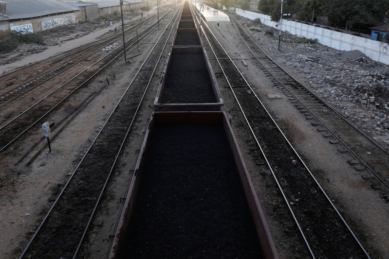 A cargo train loaded with coal dust, moves past the port area near City Station in Karachi