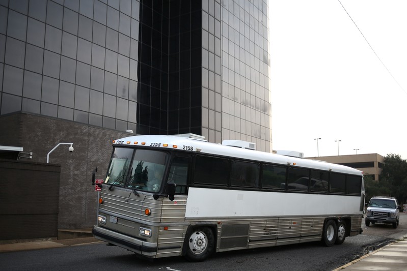 Undocumented immigrants arrive by bus at a U.S. federal court for hearings in McAllen