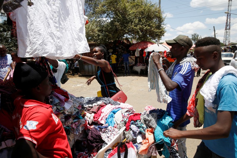 A woman looks at clothing for sale at a market in Nairobi, Kenya