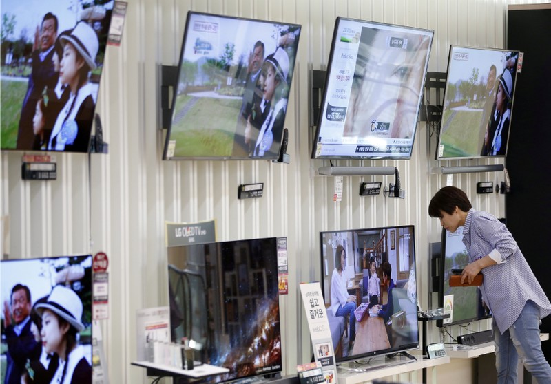 FILE PHOTO: A woman looks at a LG Electronics' OLED TV at its store in Seoul