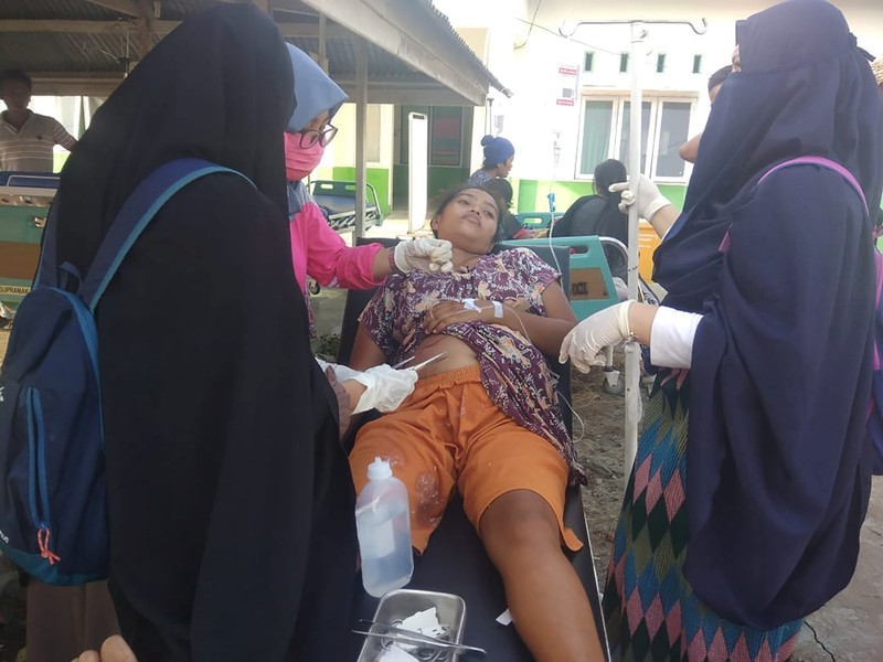 Paramedic gives treatment to an earthquake survivor outside a hospital in Donggala