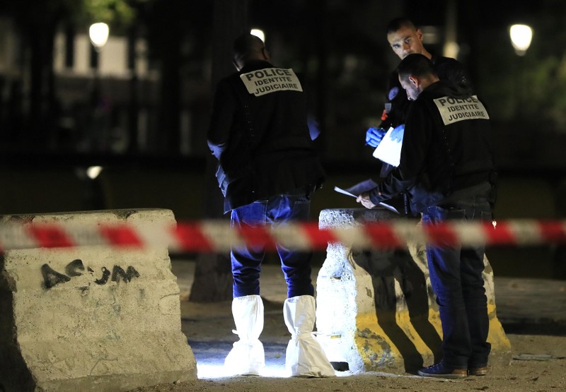 Police investigators work on the scene after seven people were wounded in knife attack downtown Paris