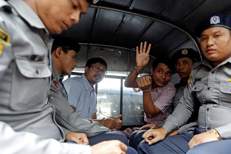 FILE PHOTO: Detained Reuters journalists Wa Lone and Kyaw Soe Oo sit beside police officers as they leave Insein court in Yangon