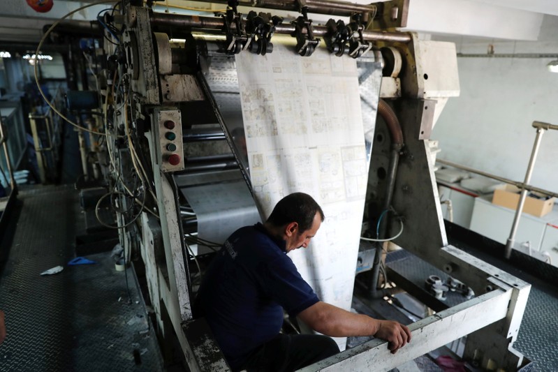 A worker monitors the print quality of Leman weekly satirical magazine in Istanbul