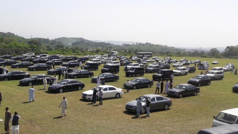 People visit an auction of government owned used cars at the premises of Prime Minister House in Islamabad