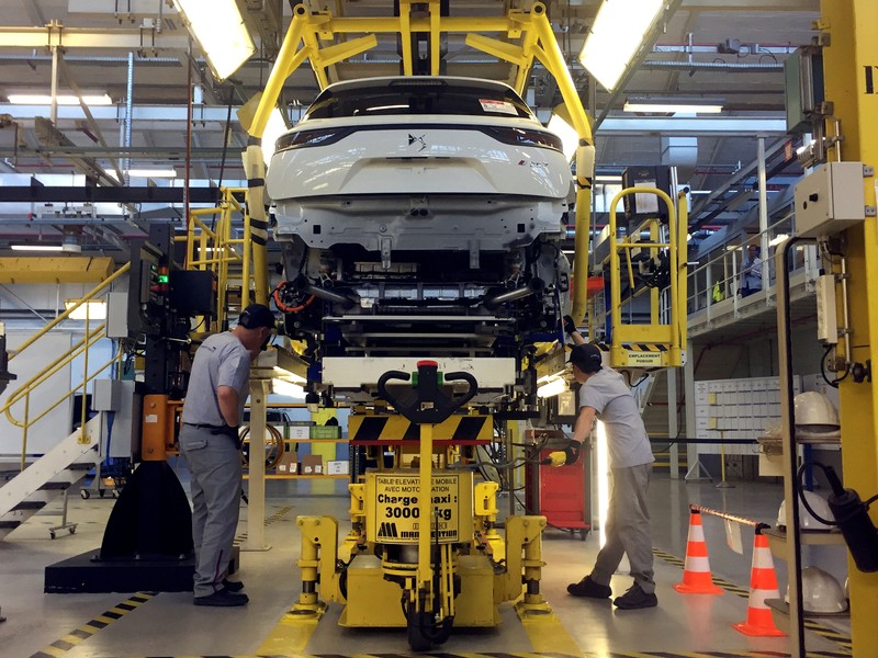 Assembly workers fix the chassis of a DS7 Crossback plug-in hybrid SUV to its body, inside the prototypes workshop at PSA GroupÕs Sochaux plant