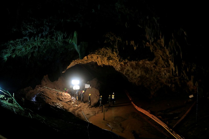 FILE PHOTO: Rescue workers follow 12 soccer players and their coach out of Tham Luang cave complex in the northern Thailand