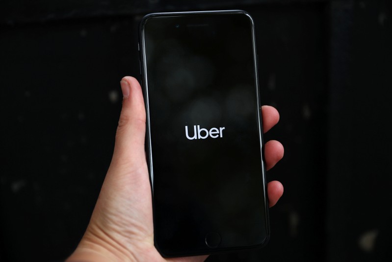 Uber's logo is displayed on a mobile phone in London