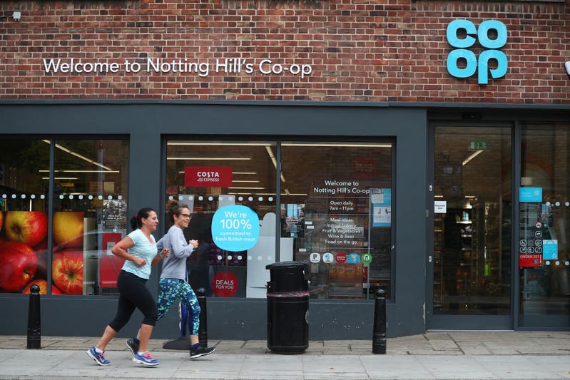 Women jog past a Co-op supermarket in London