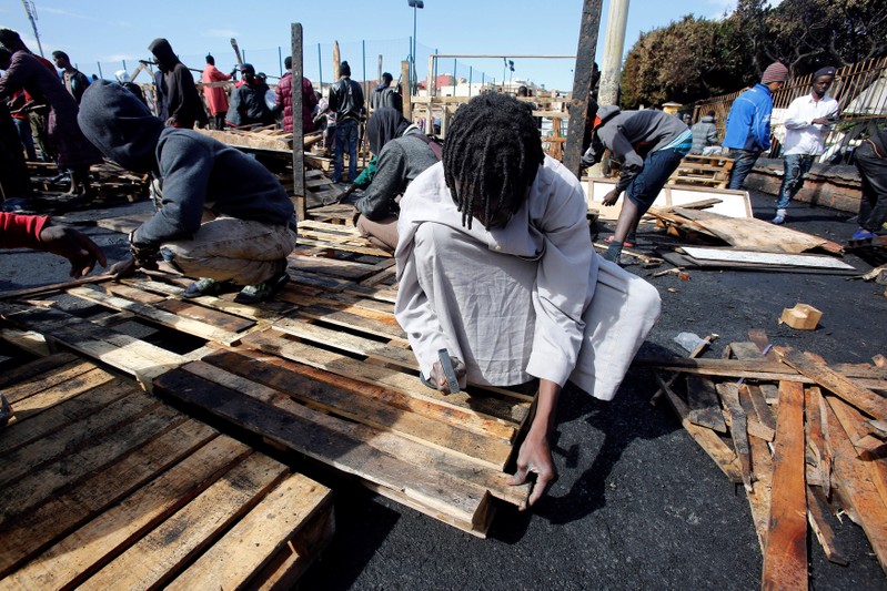 African migrants build a makeshift house after their houses burned, on the outskirts of Casablanca