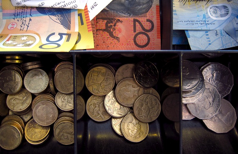 Australian dollar notes and coins can be seen in a cash register at a store in Sydney