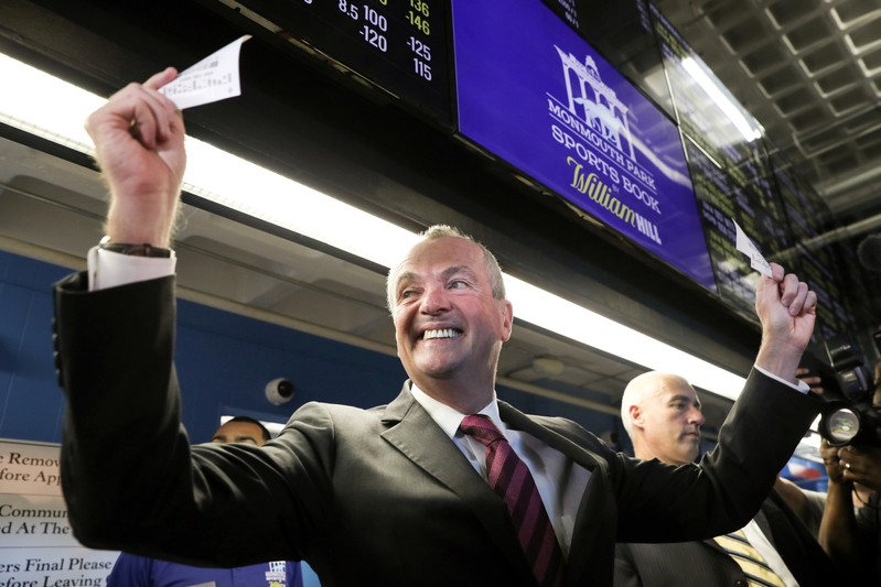 FILE PHOTO: New Jersey Governor Murphy holds up his bet tickets after placing the first legal sports bets in the State of New Jersey in Oceanport