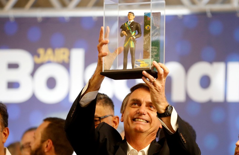 FILE PHOTO: Federal deputy Jair Bolsonaro, a candidate for Brazil's presidential elections, shows a doll of himself during a rally in Curitiba