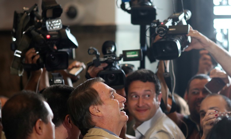 Presidential candidate Jair Bolsonaro reacts as he talks to media after a visit to Federal Police headquarters in Rio de Janeiro