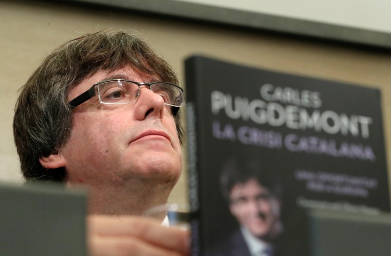 Former Catalan President Carles Puigdemont sits behind the book 