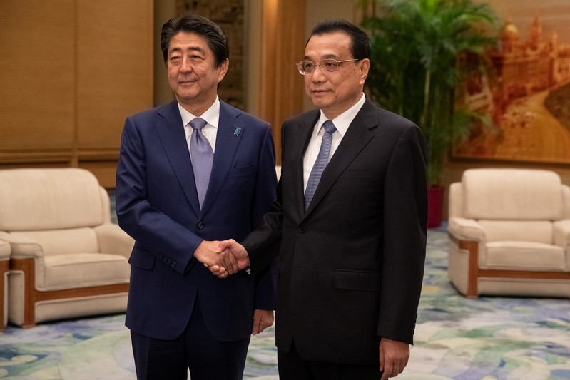 Chinese Premier Li Keqiang and Japanese Prime Minister Shinzo Abe shake hands during their meeting at the Great Hall of the People in Beijing