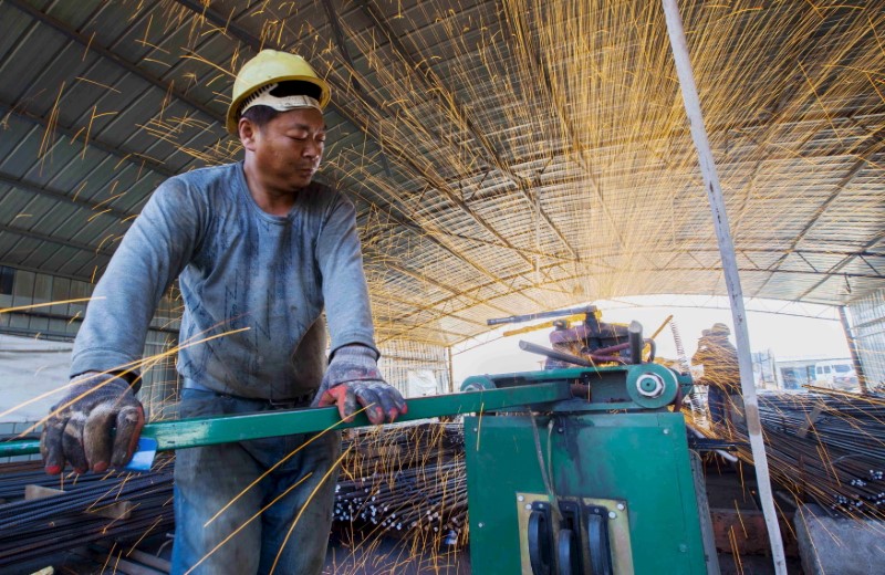 Labourer cuts steel bars at a railway bridge construction site in Lianyungang