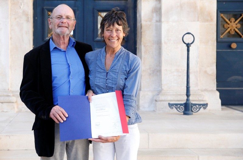 Amanda Holmes, aged 67, and Robin Holmes, aged 71, hold a French naturalization decree after a ceremony to attain French citizenship at the Sub-Prefecture in Niort