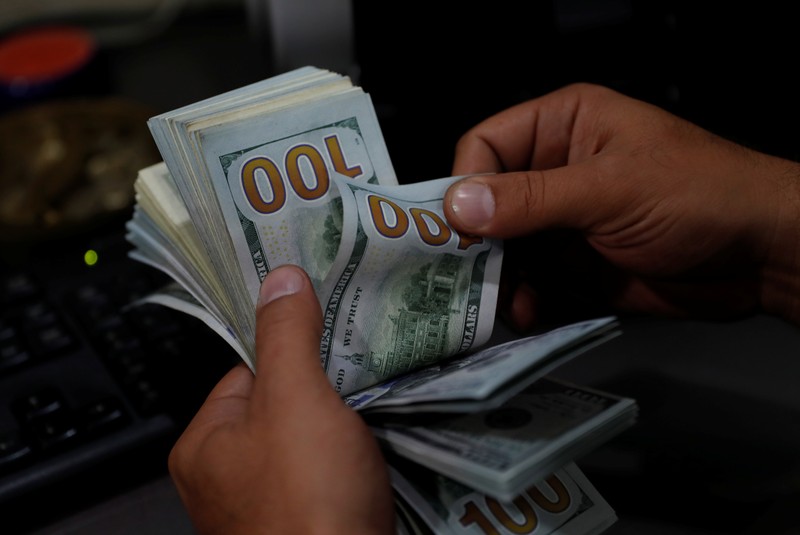 A money changer counts U.S. dollar banknotes at a currency exchange office in Izmir