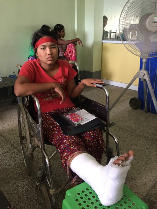 A garment worker wounded after a clash with assailants is seen in a hospital in Yangon