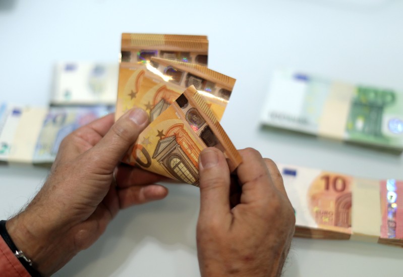 A money changer counts Euro banknotes at a currency exchange office in Nice