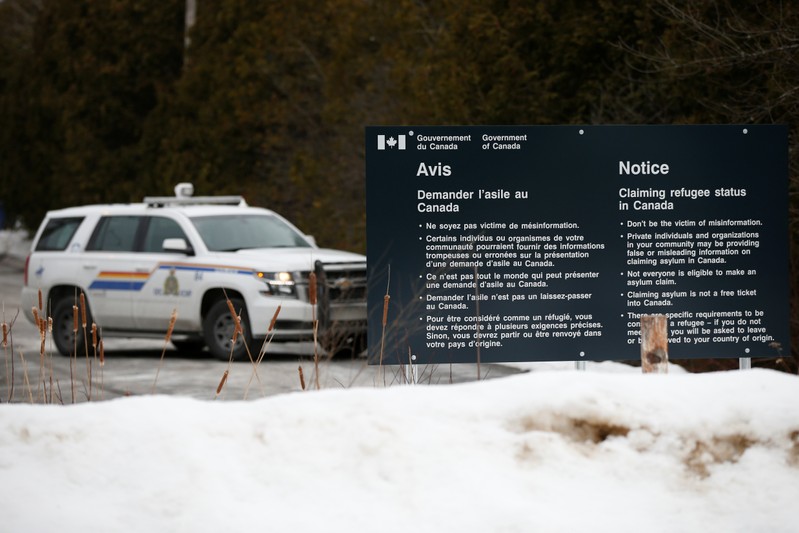 A RCMP vehicle is seen near a sign at the US-Canada border in Lacolle