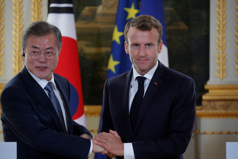 French President Emmanuel Macron and South Korean President Moon Jae-in shake hands during a joint news conference at the Elysee Palace in Paris