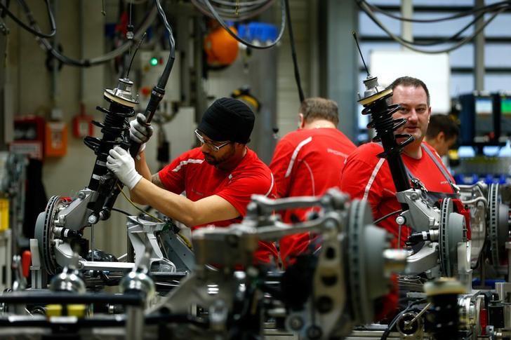 Employees of German car manufacturer Porsche work chassis at the Porsche factory in Stuttgart-Zuffenhausen
