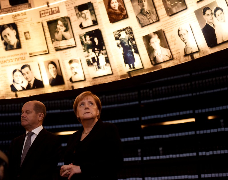 German Chancellor Angela Merkel looks at pictures of Jews killed in the Holocaust during a visit to the Hall of Names in the Holocaust History Museum at the Yad Vashem World Holocaust Remembrance Center in Jerusalem