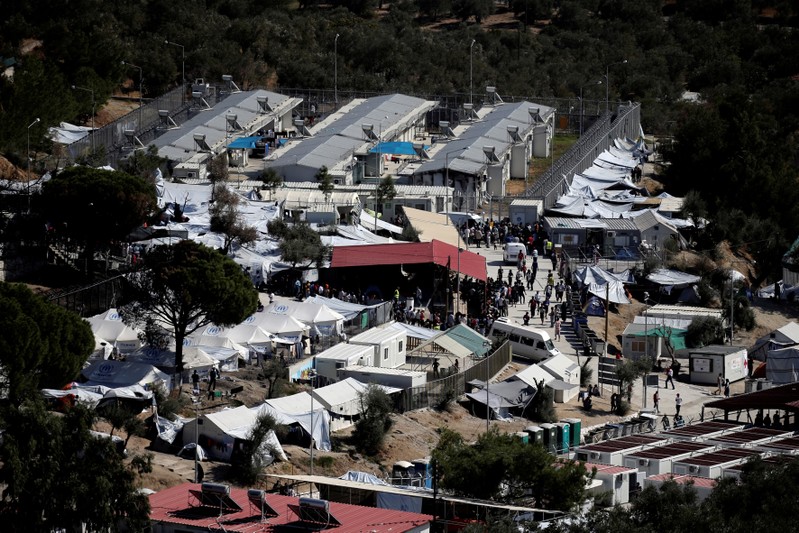 FILE PHOTO: People make their way inside the Moria migrant camp on the island of Lesbos