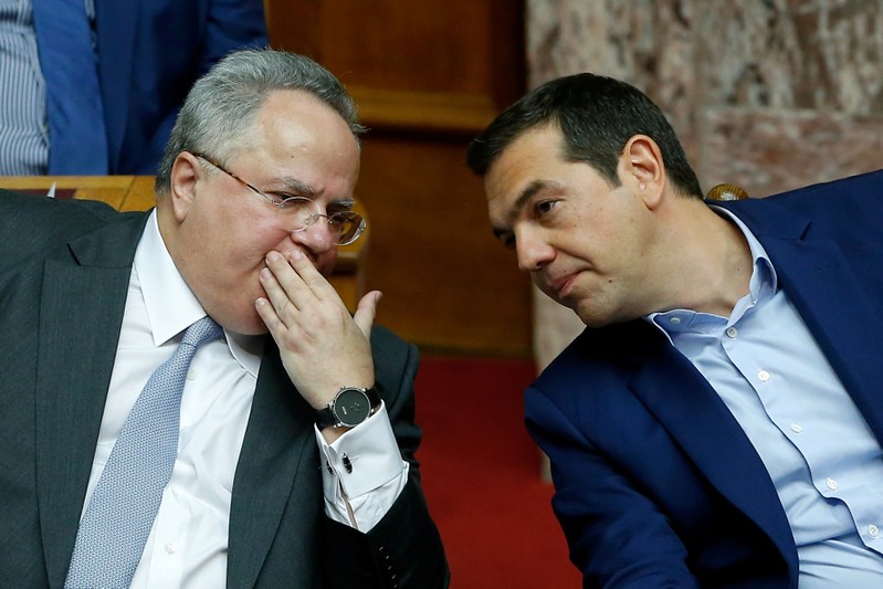 FILE PHOTO: Greek PM Tsipras speaks with Greek Foreign Minister Kotzias during a parliamentary session before a vote following a motion of no confidence by the main opposition in dispute over a deal on neighbouring Macedonia's name