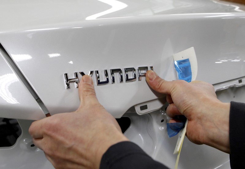 FILE PHOTO: A worker fixes the Hyundai logo on a vehicle at a plant of Hyundai Motor in Asan, south of Seoul