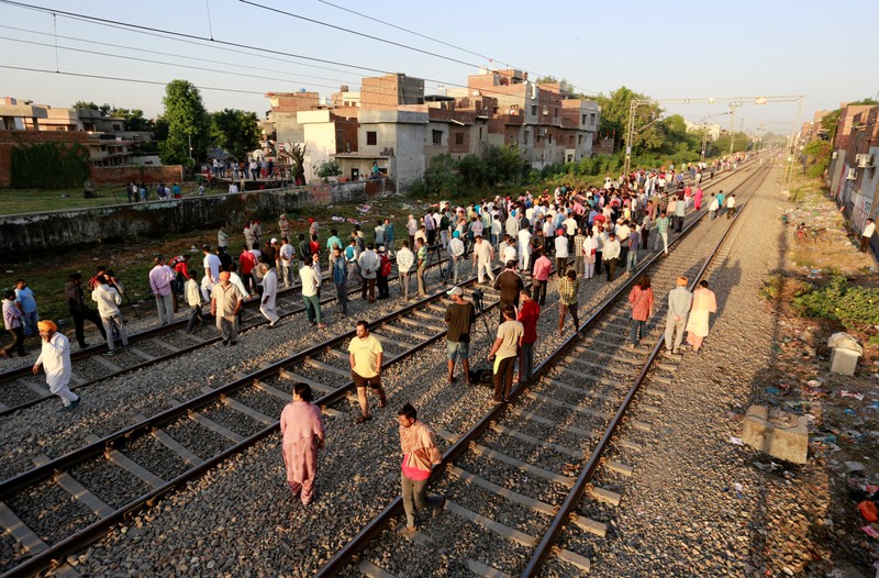 People gather at the site of an accident after a commuter train traveling at high speed ran through a crowd of people on the rail tracks in Amritsar