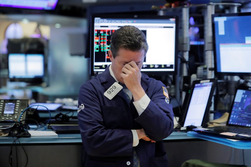 A trader pauses as he works on the floor of the NYSE in New York