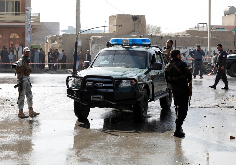 Afghan policemen keep watch at the site of a suicide attack in Kabul