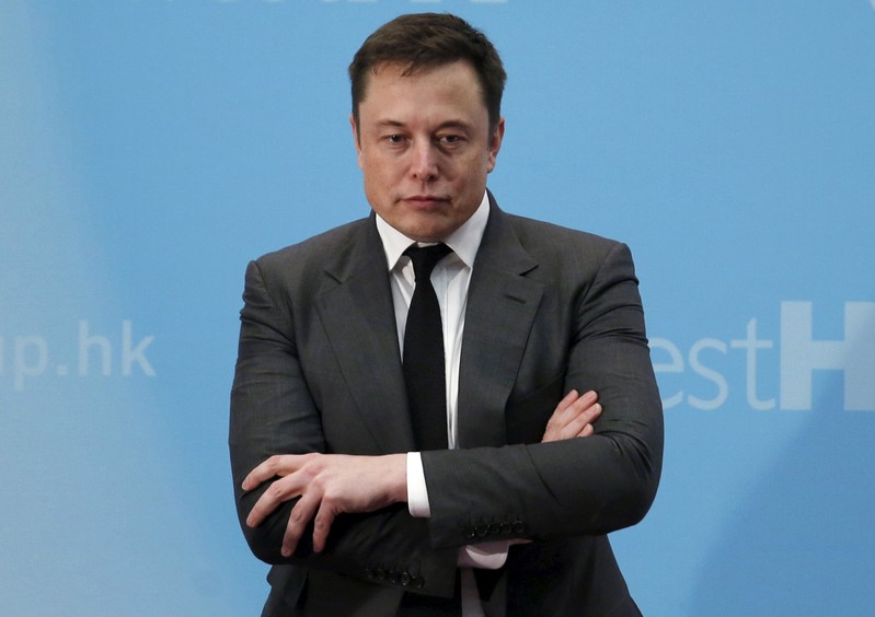 FILE PHOTO: Tesla Chief Executive Elon Musk stands on the podium as he attends a forum on startups in Hong Kong