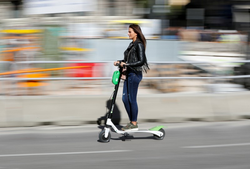 A woman rides a dock-free electric scooter Lime-S by California-based bicycle and scooter sharing service Lime, on a street in Madrid