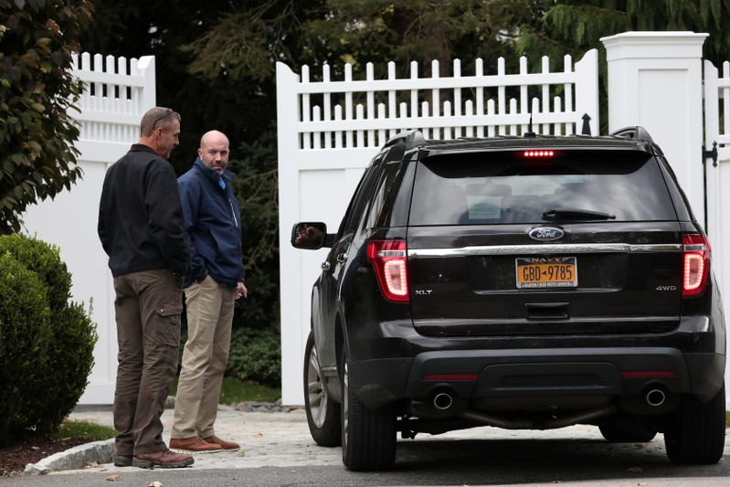 People stand outside the gatehouse of Bill and Hillary Clinton's house in Chappaqua