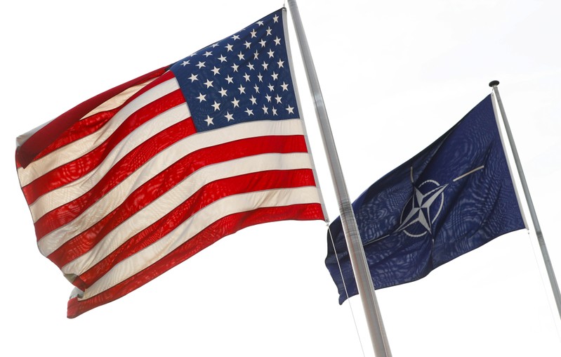NATO and U.S. flags fly at the entrance of the Alliance's headquarters during a NATO foreign ministers meeting in Brussels