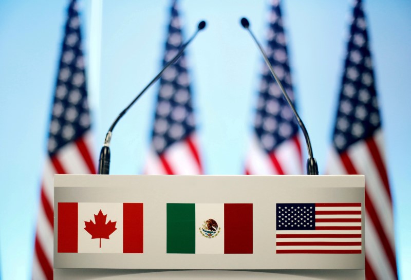 FILE PHOTO: The flags of Canada Mexico and the U.S. are seen on a lectern before a joint news conference of NAFTA talks in Mexico City
