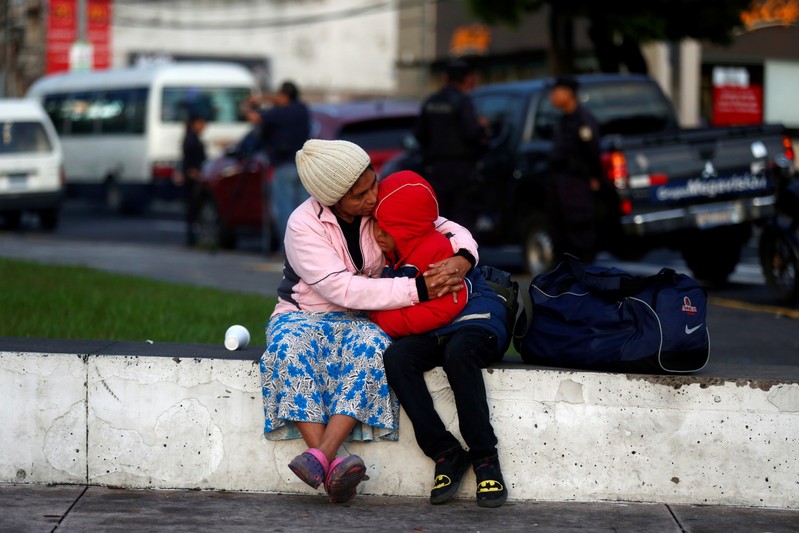 A woman holds her son before departing with a caravan of migrants from El Salvador en route to the United States, in San Salvador