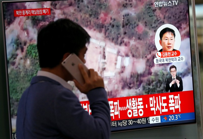 FILE PHOTO: A man walks past a TV broadcasting a news report on the dismantling of the Punggye-ri nuclear testing site, in Seoul