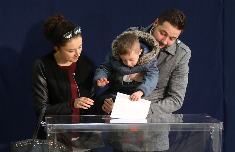 Patryk Jaki, United Right candidate for mayor of Warsaw, accompanied by his wife and son casts a vote during the Polish regional elections, at a polling station in Warsaw