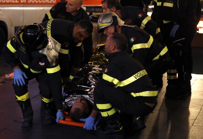 Fire fighters carry an injured person outside the underground where some of CSKA Moscow supporters were injured in Rome